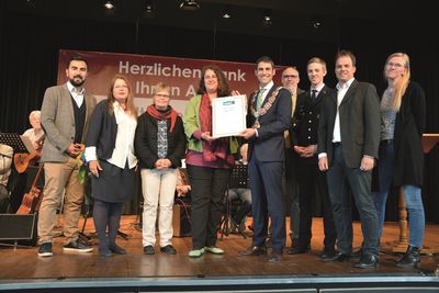 Bild vergr&ouml;&szlig;ern: Carina Bischke, externe Referentin Fairtrade Deutschland, &uuml;berreichte B&uuml;rgermeister Dr. Alexander Legler und der Fairtrade-Steuerungsgruppe die Urkunde, die Alzenau offiziell als Fairtrade-Stadt auszeichnet.