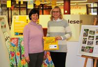 Bild vergr&ouml;&szlig;ern: Bundestagsabgeordnete Andrea Lindholz und Bibliotheksleitung Christl Huber verteilen w&auml;hrend des Weihnachtsmarktes Lesestart-Taschen